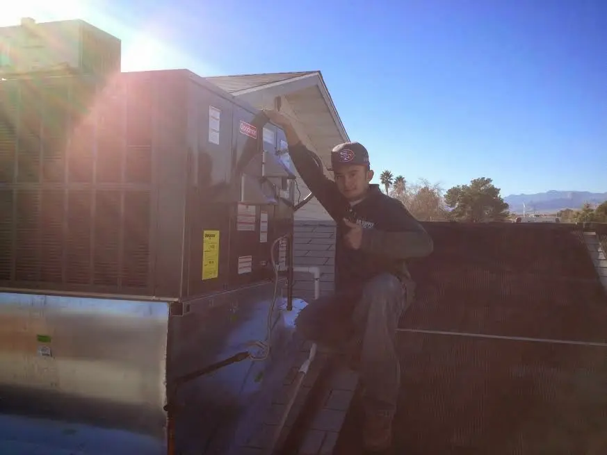 HVAC technician performing Boiler Repair on a rooftop unit in Abilene